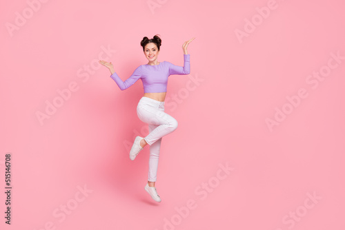 Full length photo of cheerful satisfied lady enjoy free time jumping isolated on pink color background