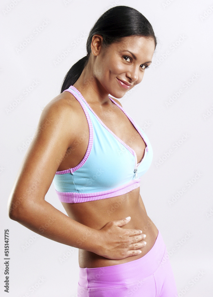 Latin woman touching her belly after training workout. Latin woman touching her belly after training workout.