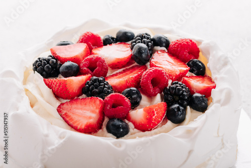 Pavlova meringue cake with fresh berries on white background