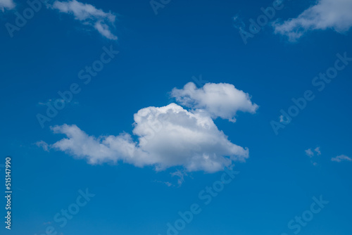 Puffy white clouds set against deep blue sky  no people