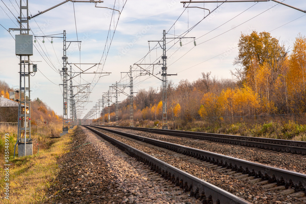 Railroad with power supply pytons in autumn season. Travel landscape