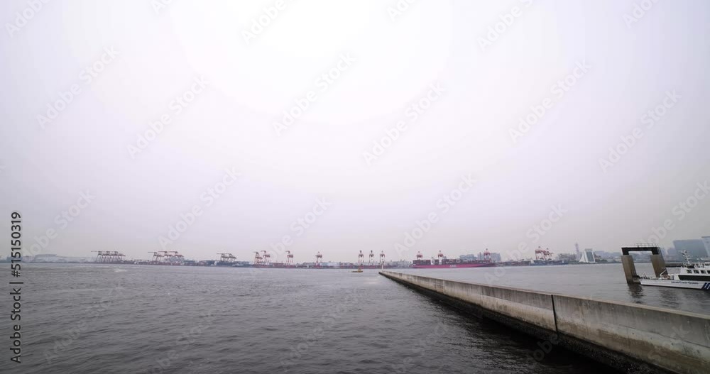 A large ship near the container wharf in Tokyo cloudy day wide shot A large ship near the container wharf in Tokyo cloudy day wide shot