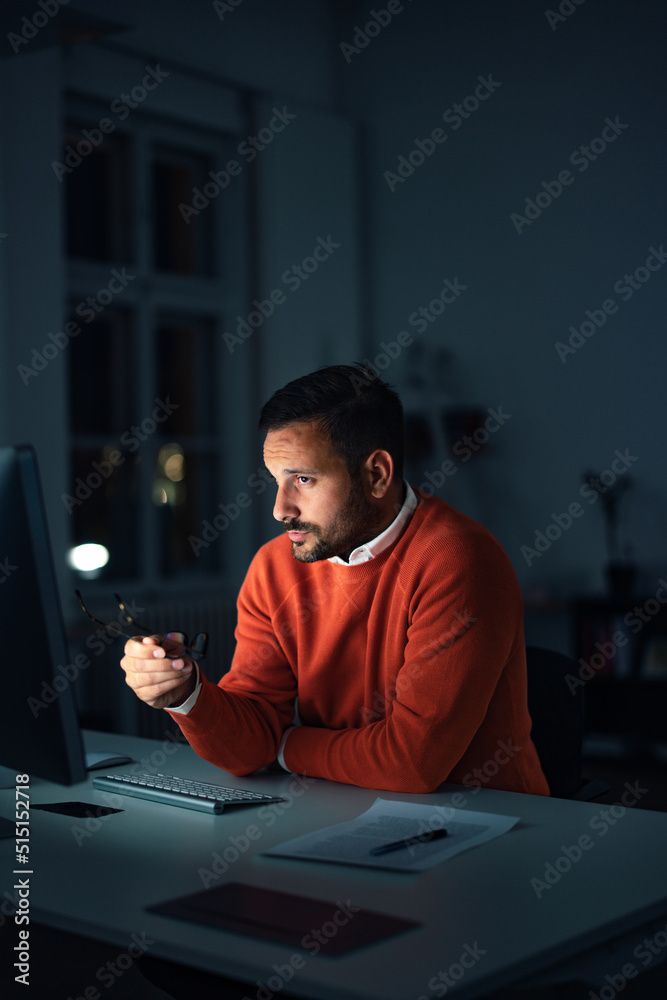 Serious man holding glasses, discussing with one client, online.