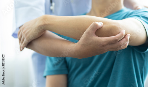 Concept of physical therapy and rehabilitation. A man with shoulder pain goes to the doctor, The doctor diagnoses the patient's arm pain and shoulder pain.