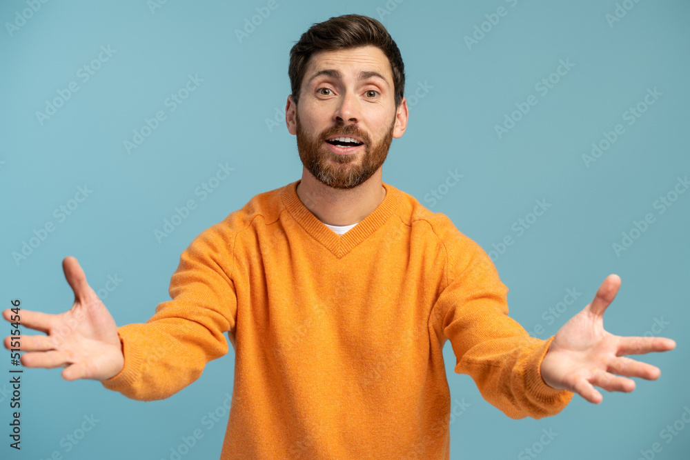 Come to me! Portrait of friendly kind man holding arms wide open for free hugs and smiling happily, welcoming, going to embrace. Indoor studio shot isolated on blue background Come to me! Portrait of friendly kind man holding arms wide open for free hugs and smiling happily, welcoming, going to embrace. Indoor studio shot isolated on blue background