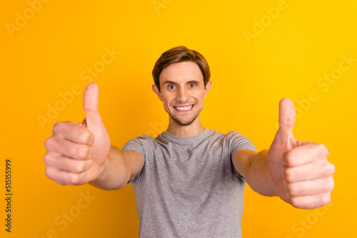Young man wearing casual clothes over bright background approving doing positive gesture hand thumbs up smiling success © Tetiana