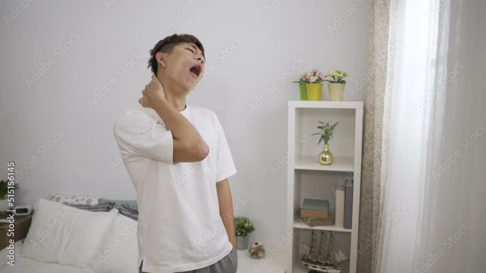 portrait of a bored Japanese boy yawning and picking eye booger while standing near the window looking outside in the early morning at his bedroom. portrait of a bored Japanese boy yawning and picking eye booger while standing near the window looking outside in the early morning at his bedroom.