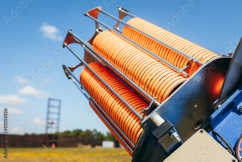 Close up plat machine with orange shooting plate for shooting-ground training on field with grass