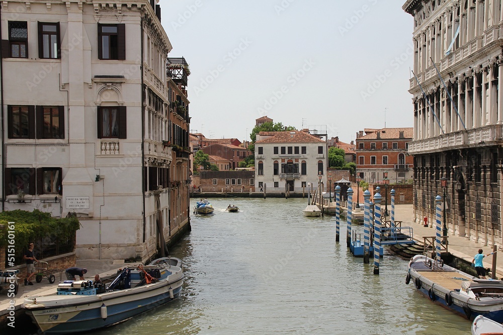 Venice, blue and white posts in the Venice water canal, water canal, classical architecture, boats parked along the canal