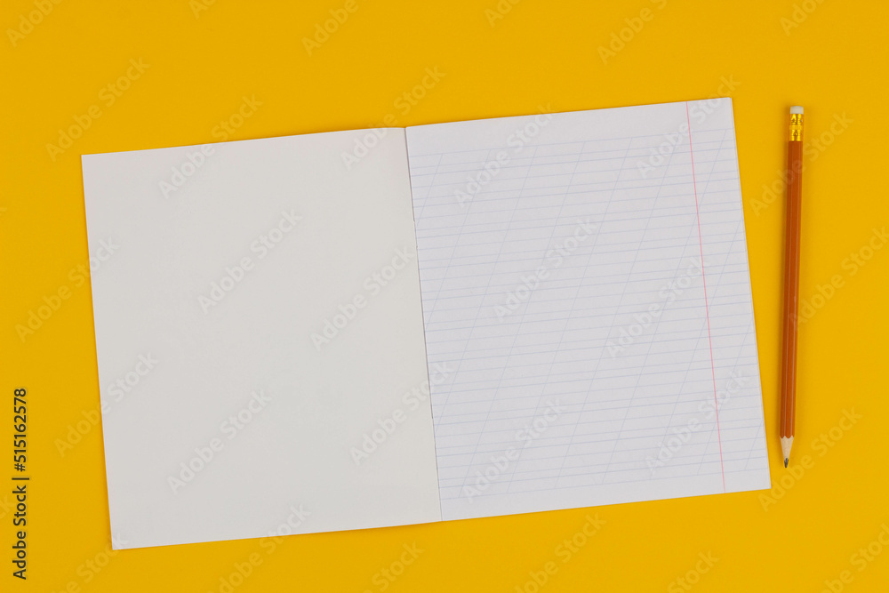 School notebook on a yellow background with copy space for text and pencil. Back to school. Blank sheet of paper with oblique lines in exercise book. school Supplies. Top view School notebook on a yellow background with copy space for text and pencil. Back to school. Blank sheet of paper with oblique lines in exercise book. school Supplies. Top view