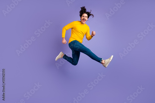 Full size portrait of excited satisfied person jumping have fun good mood isolated on purple color background © deagreez
