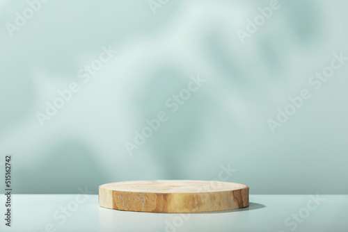 Wood slice podium with leaves shadows on blue background for cosmetic product mockup