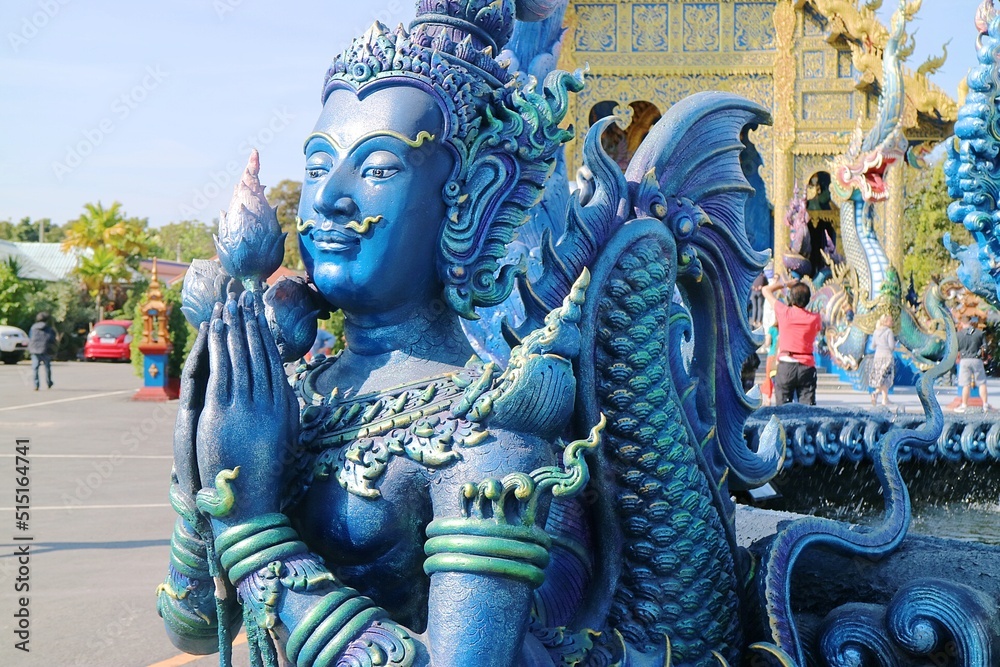 Closeup of blue buddha statue in prayer pose