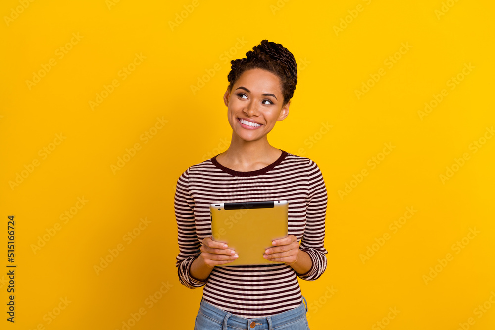 Photo of cheerful charming lady hands hold tablet look interested empty space isolated on yellow color background Photo of cheerful charming lady hands hold tablet look interested empty space isolated on yellow color background