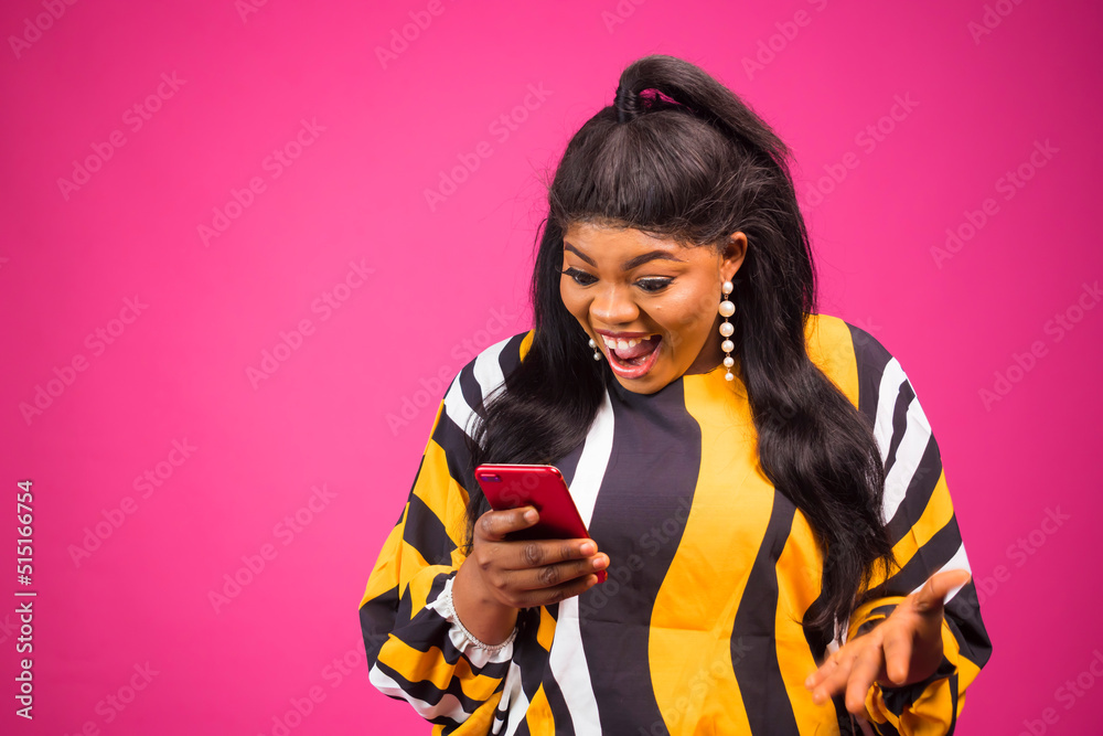 Joyful Black pluse size Female Using New Smartphone Standing Over PINK Background Joyful Black pluse size Female Using New Smartphone Standing Over PINK Background