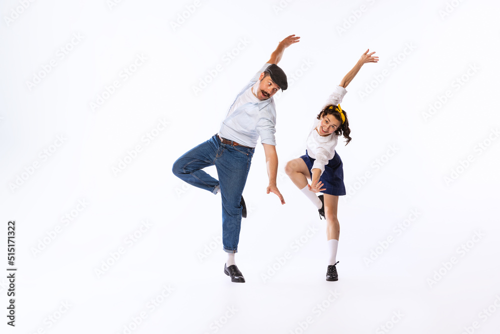 Portrait of beautiful couple, man and woman, dancing isolated over white studio background. Retro party