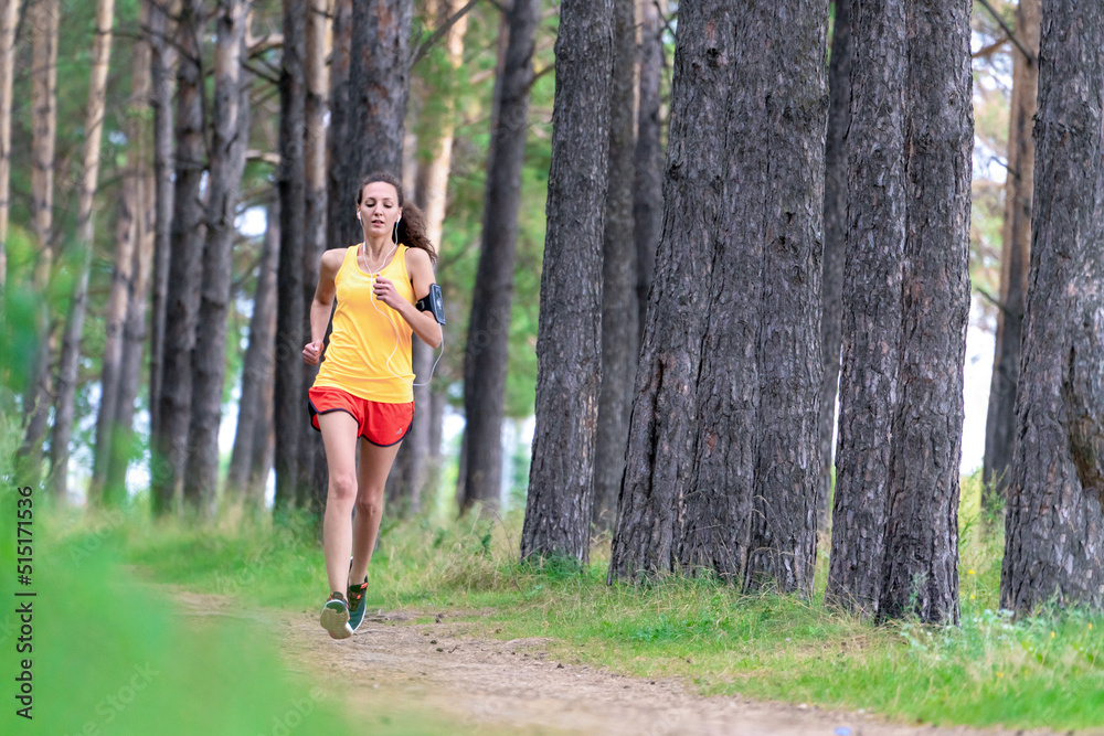 Running woman. Female runner jogging at the park. Girl training outdoors. Exercising on forest path. Healthy, fitness, wellness lifestyle. Sport, cardio, workout concept Running woman. Female runner jogging at the park. Girl training outdoors. Exercising on forest path. Healthy, fitness, wellness lifestyle. Sport, cardio, workout concept