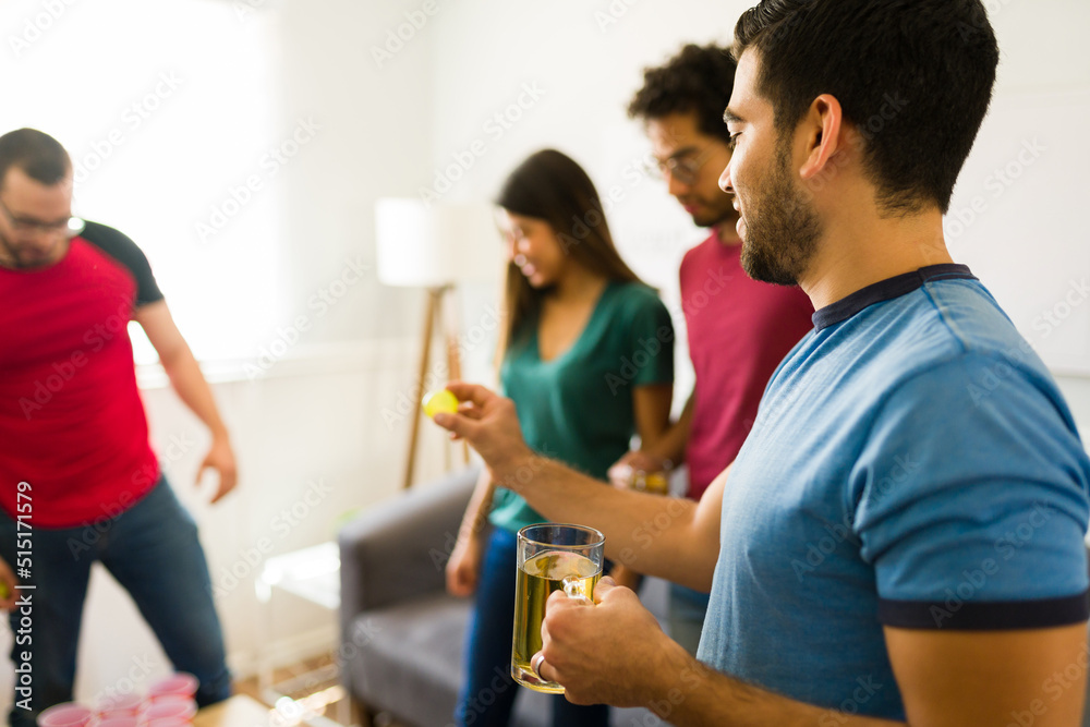 Hispanic friends playing a drinking game at a fun party Hispanic friends playing a drinking game at a fun party