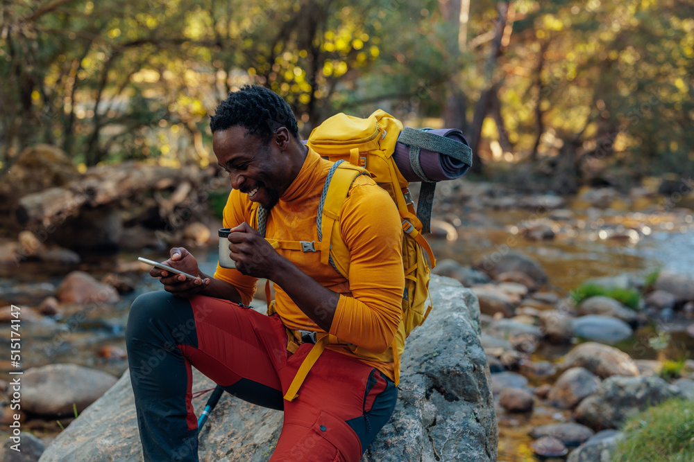 Hiker taking break reading messages on cellphone