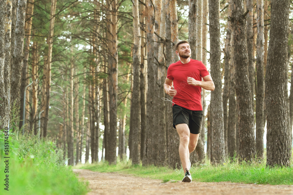 Running man. Male runner jogging at the park. Guy training outdoors. Exercising on forest path. Healthy, fitness, wellness lifestyle. Sport, cardio, workout concept Running man. Male runner jogging at the park. Guy training outdoors. Exercising on forest path. Healthy, fitness, wellness lifestyle. Sport, cardio, workout concept