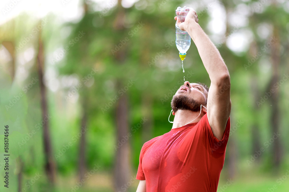 Fitness man drinking water from bottle. Thirsty athlete having cold refreshment drink after