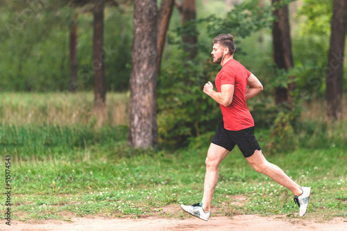 Running man. Male runner jogging at the park. Guy training outdoors. Exercising on forest path. Healthy, fitness, wellness lifestyle. Sport, cardio, workout concept