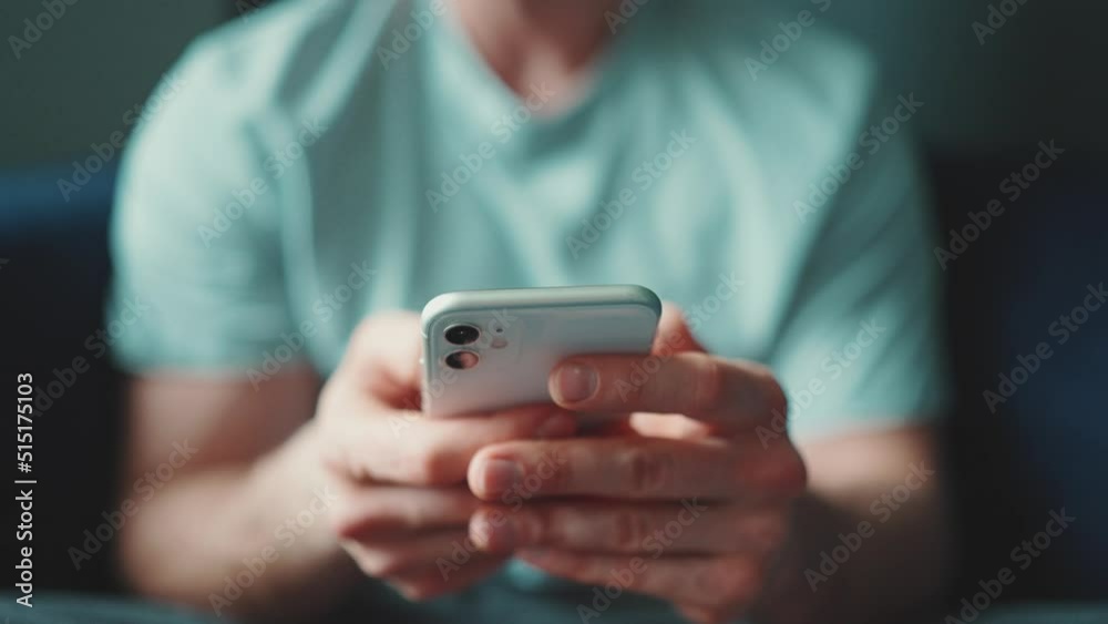 Male hands typing on mobile indoors at home Male hands typing on mobile indoors at home