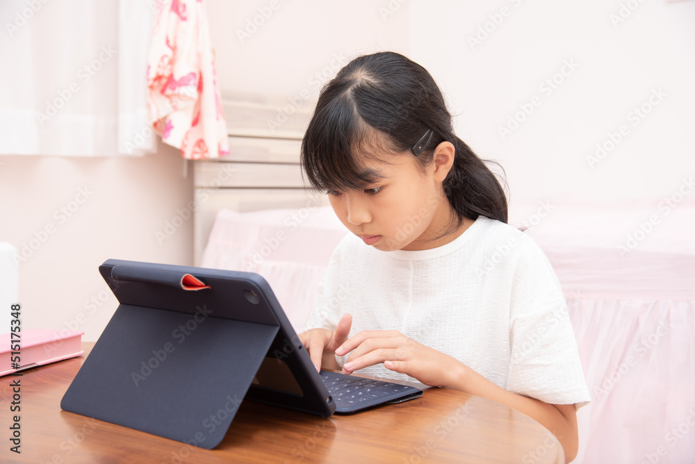 子供部屋でタブレット学習をする小学生の女の子 子供部屋でタブレット学習をする小学生の女の子