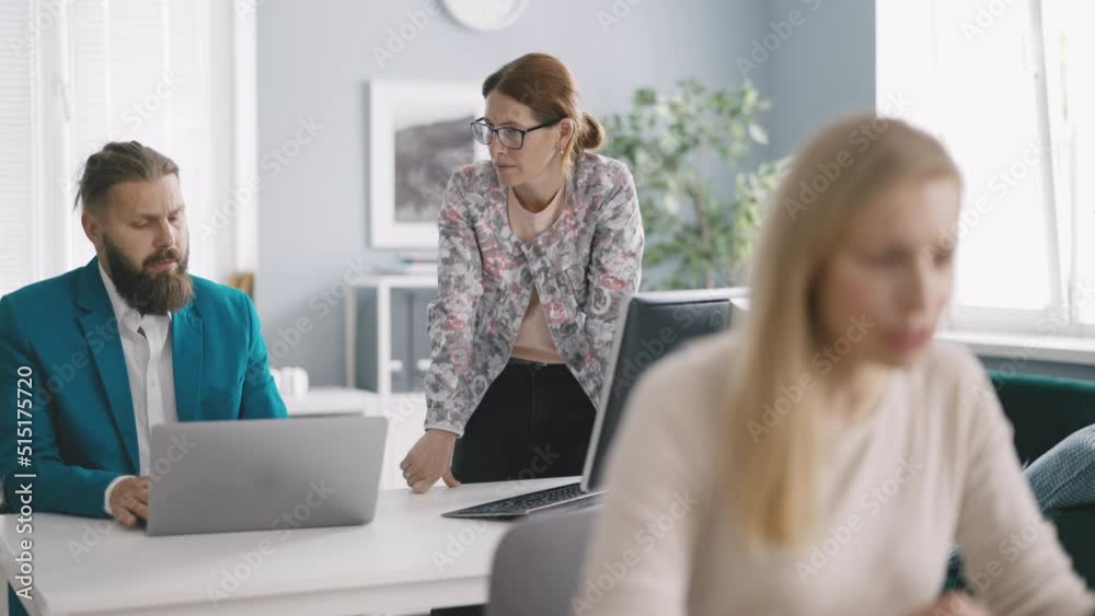 Beautiful female manager asking for professional advice from her male colleague using laptop in comfortable office. Contemporary business people working as team. Beautiful female manager asking for professional advice from her male colleague using laptop in comfortable office. Contemporary business people working as team.