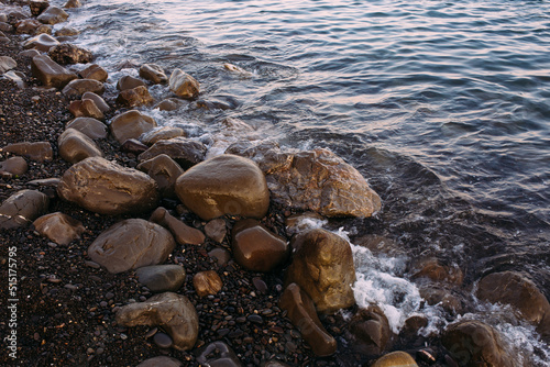  Seashore with pebbles and stones in the evening at sunset