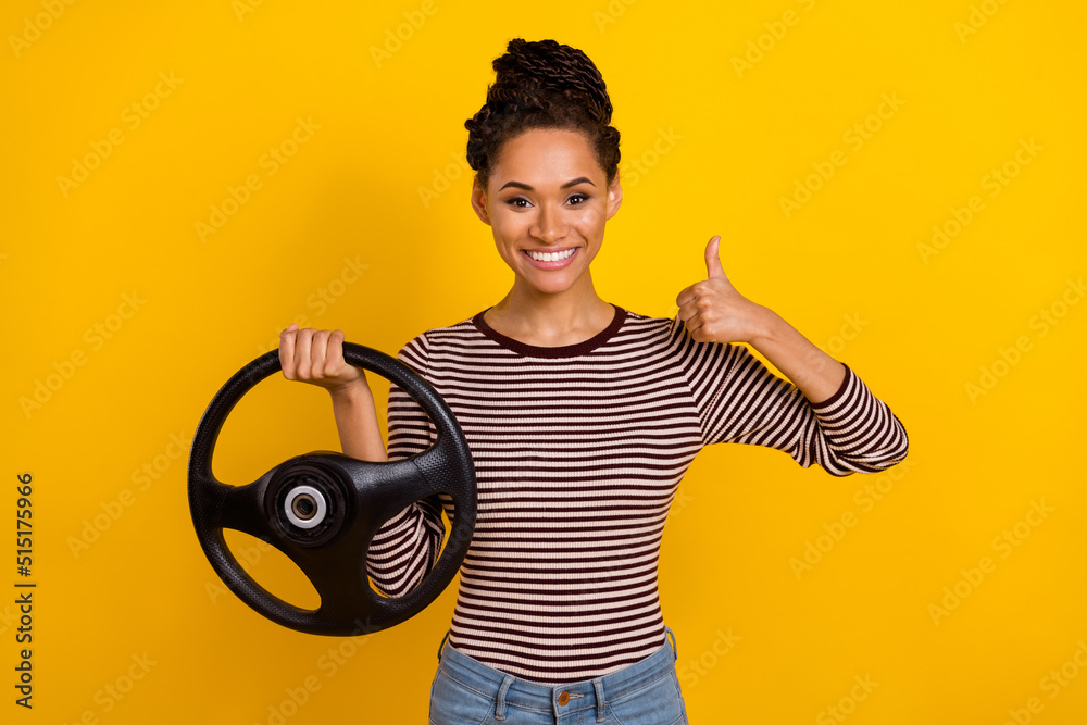 Photo of positive nice lady arm hold wheel demonstrate thumb up feedback rate isolated on yellow color background Photo of positive nice lady arm hold wheel demonstrate thumb up feedback rate isolated on yellow color background
