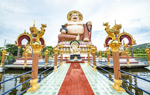 A large Buddha image sits in the middle of the water at Wat Plai Laem on Koh Samui, Sarat Thani Province, Thailand photo