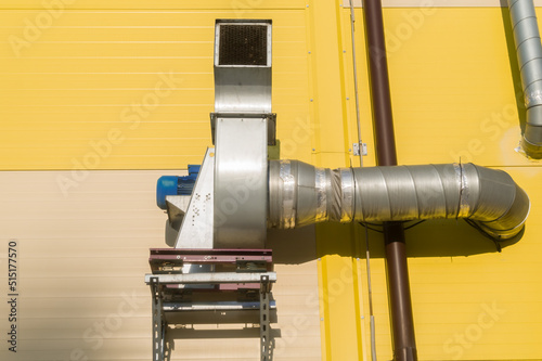 Dirty air extraction system. Equipment installed outside the building for exhaust and air filtration. Electric motor with an air pipe on the wall of the building. Selective focus