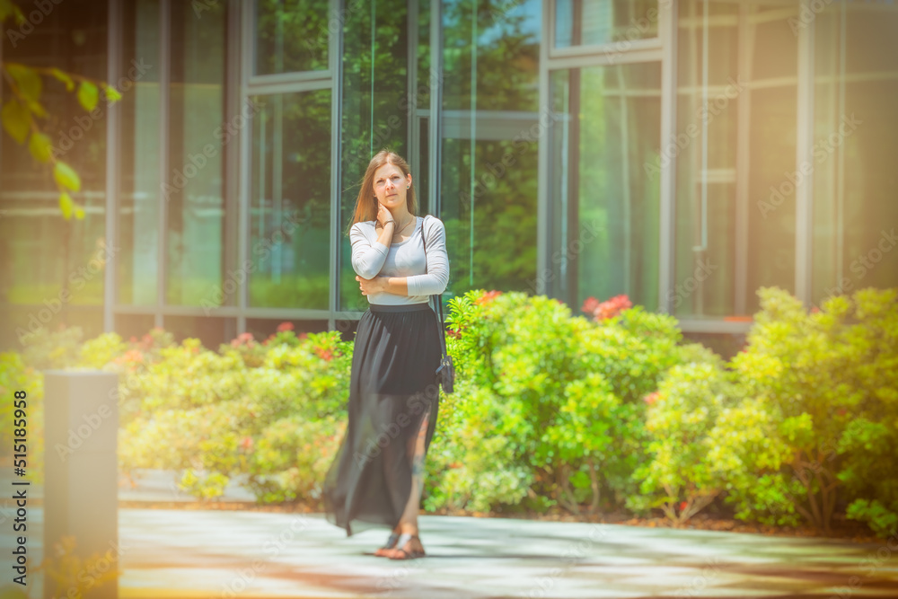 Young attractive woman in dress. Business park. City park. Concept photo.