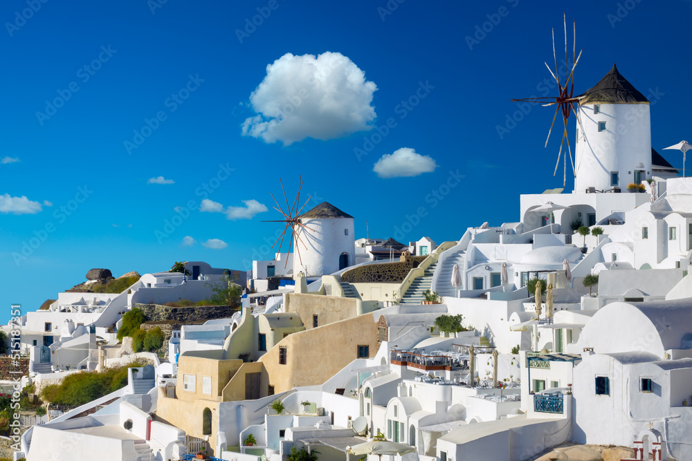 Windmills and cityscape of Oia town on Santorini island in Greece. Traditional white houses. Greece, Aegean Sea. Popular European destination