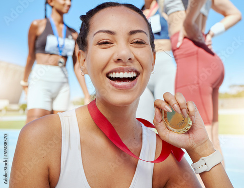 Closeup portrait of mixed race athletic woman showing gold medal from competing in sports event. Smiling fit active latino athlete feeling proud after winning running race.