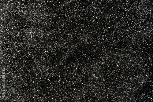 Black glitter sparkle background texture. Scattered abstract background for any celebration