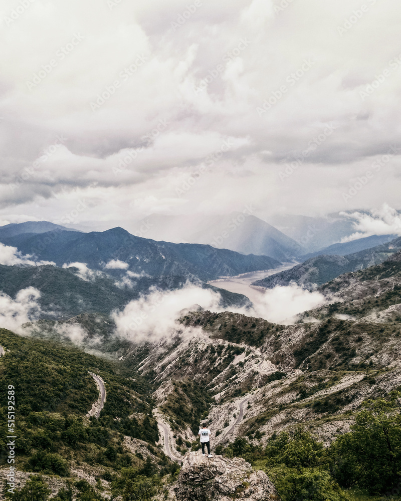 Man standing on rocks looking at clouds, aerial view. Kozjak, north Macedonia