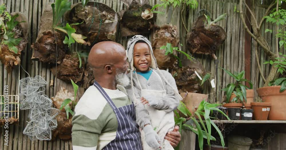 Portrait of happy senior african american man with his grandson embracing and smiling in garden Portrait of happy senior african american man with his grandson embracing and smiling in garden