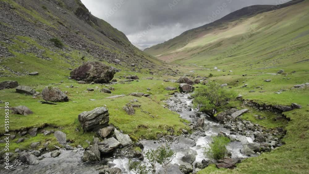 A river flowing down a valley in the English Lake District. Large Rocks are scattered all around. Honister pass A river flowing down a valley in the English Lake District. Large Rocks are scattered all around. Honister pass