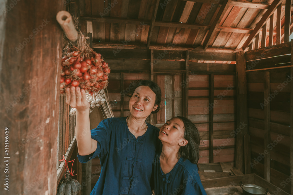 Obraz premium Mother and children see vegetable for cooking in house of countryside