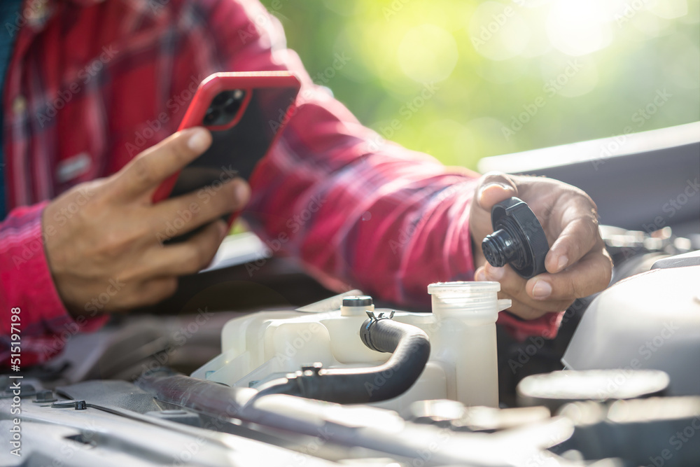 Man opening cap of car radiator to checking up the engine before start the trip. Car maintenance or check up concept Man opening cap of car radiator to checking up the engine before start the trip. Car maintenance or check up concept