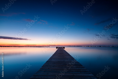 Fototapeta Naklejka Na Ścianę i Meble -  Horizontal photo of the sunrise and the calm waters of the Mar Menor, Region of Murcia, Spain, from a wooden jetty in San Javier