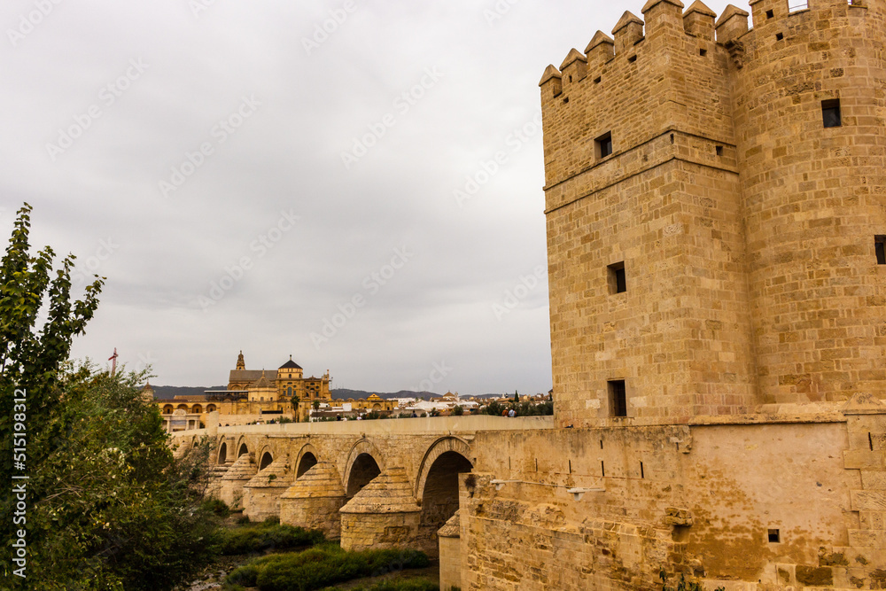 Cordoba, Spain, September 13, 2021: The defensive tower from the Muslim era: the Calahorra Tower, Guadalquivir River, and the Roman Bridge, with Cordoba Mosque-Cathedral in the background.