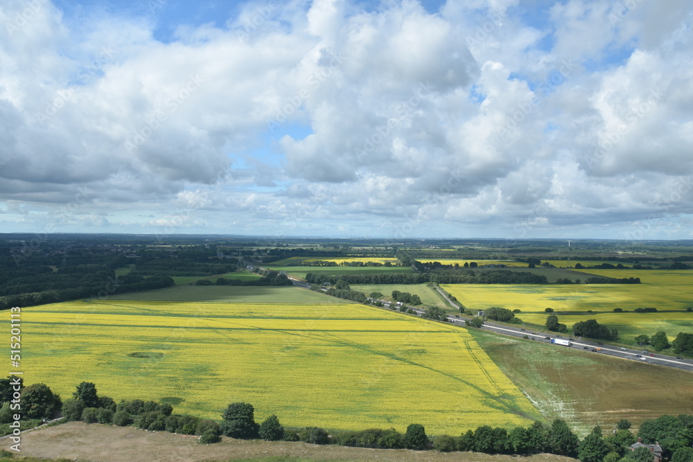 Fototapeta premium Aerial view of farmland and roads with a cloudy sky background. 