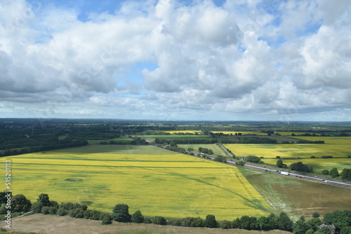 Aerial view of farmland and roads with a cloudy sky background. 