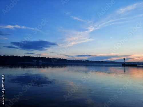 Beautiful landscape view of sea  clouds reflected in the water  natural minimalistic background and texture  river scenery  summer sunset