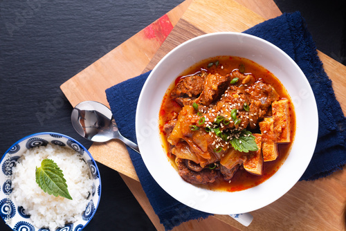 Asian food concept homemade Kimchi Beef Stew Kimchi Jjigae on wooden board and black slate stone with copy space photo