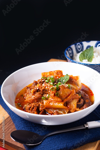Asian food concept homemade Kimchi Beef Stew Kimchi Jjigae on wooden board and black slate stone with copy space
