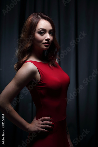Girl in a red dress on a dark background